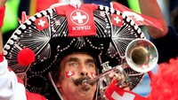 Pemandangan unik juga terlihat saat laga pertandingan Swiss kontra Serbia. Salah seorang suporter Swiss tampil meriah dengan topi sombrero berhias bendera dan jersey timnas Swiss. Istimewa/Gonzalo Fuentes/Reuters.