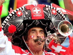 Pemandangan unik juga terlihat saat laga pertandingan Swiss kontra Serbia. Salah seorang suporter Swiss tampil meriah dengan topi sombrero berhias bendera dan jersey timnas Swiss. Istimewa/Gonzalo Fuentes/Reuters.