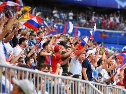 Fans Rusia memberikan dukungan dengan mengibarkan bendera. Reuters/Dylan Martinez.