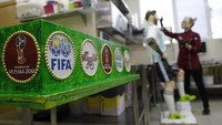 Ini fondasi yang akan jadi tatakan kue ultah Messi. Ada sejumlah logo, di antaranya logo Piala Dunia 2018. (Foto: Tatyana Makeyeva/Reuters)
