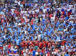 Tak mau kalah, fans Uruguay juga terus memberikan semangat kepada Luis Suarez dkk. Reuters/Dylan Martinez.