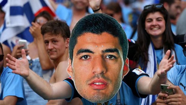 Seorang fan uruguay mengenakan topeng Luis Suarez saat timnya bertemu Rusia, di Samara Arena, Samara, Rusia, 25 Juni.