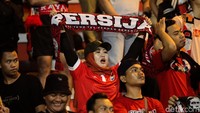 Pendukung Persija memberikan dukungan dengan meneriakkan yel-yel sambil membentangkan syal.