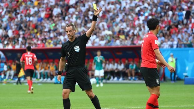 Wasit Mark Geiger memberikan kartu kuning kepada pemain timnas Korea Selatan Son Heung-min.
