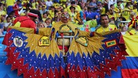 Fans Kolombia yang mengenakan kostum unik meneriakkan yel-yel dukungan dari tribun penonton. Reuters/Marcos Brindicci.