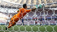 Kiper Jepang Eiji Kawashima melakukan penyelamatan gemilang dengan menahan sundulan Kamil Grosicki. Meski posisinya seperti mati langkah, Kawashima masih mampu menepis bola yang nyaris masuk ke gawang. (Foto: Richard Heathcote/Getty Images)