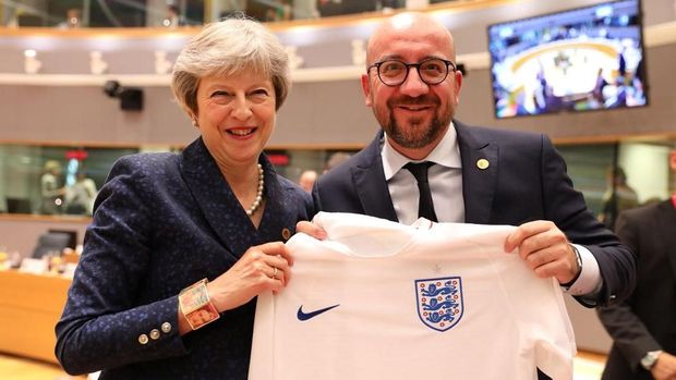 Theresa May balas memberi jersey timnas Inggris kepada Michel.