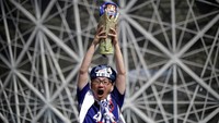 Seorang fans merayakan kelolosan sambil mengangkat trofi Piala Dunia. Reuters/Ueslei Marcelino.