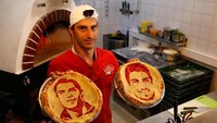 Pizza dengan topping berhias wajah para pemain bola ini menjadi populer di kalangan masyarakat. Khususnya bagi para pecinta bola yang datang untuk mendukung timnas kebanggan mereka bertanding di Rusia. Anton Vaganov/Reuters.