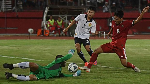Pesepak Indonesia U19 Witan Sulaeman (kanan) berusaha menendang bola yang dihalau penjaga gawang Laos U19 Kitom Venvongsot (kiri) dalam penyisihan grup A Piala AFF U19 di Gelora Delta Sidoarjo, Sidoarjo, Jawa Timur, Minggu (1/7). Indonesia unggul atas Laos 1-0. ANTARA FOTO/Zabur Karuru/ama/18