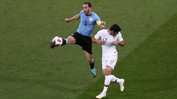Bek timnas Uruguay Diego Godin berduel dengan pemain timnas Portugal Goncalo Guedes di Piala Dunia 2018.