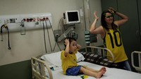 Salah satu penderita kanker Octavio (6) didamping ibunya menyaksikan laga Brasil vs Meksiko di RS Itaci, Sao Paulo, REUTERS/Nacho Doce.