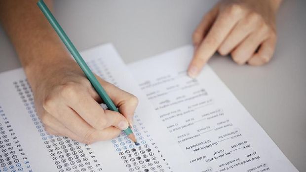 Close up of hands of student doing test.