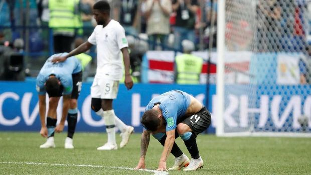 Para pemain Uruguay tertunduk lesu usai dikalahkan Prancis.