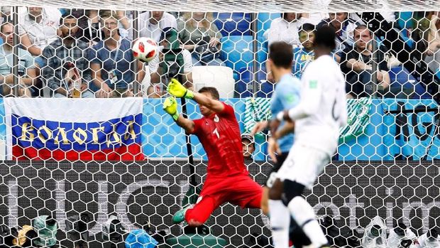 Kiper timnas Uruguay Fernando Muslera tak sempurna menepis tendangan Griezmann.