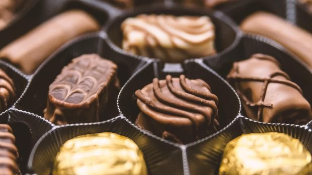 Different sorts of chocolates. Chocolate candy in the box. Chocolate sweets. An assortment of fine chocolates in white, dark, and milk chocolate. Delicious box of chocolates in close up