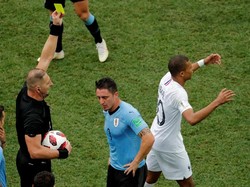 Wasit Pitana kemudian memberi kartu kuning buat Rodriguez dan juga Mbappe, yang tampak tak percaya dirinya pun terkena kartu. (Foto: Carlos Barria/Reuters)
