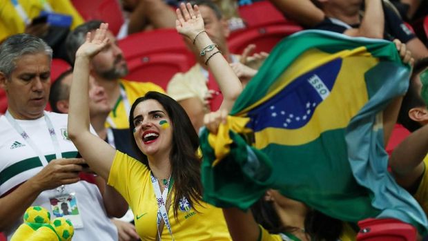 Suporter mengibarkan bendera Brasil dalam laga di Kazan Arena, Kazan, Rusia, 6 Juli.