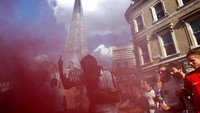 Di London, pesta berlangsung lebih gila. Fans Inggris yang terkenal fanatik menyalakan flare yang membuat kawasan itu menjadi merah. (Foto: Henry Nichols/Reuters)