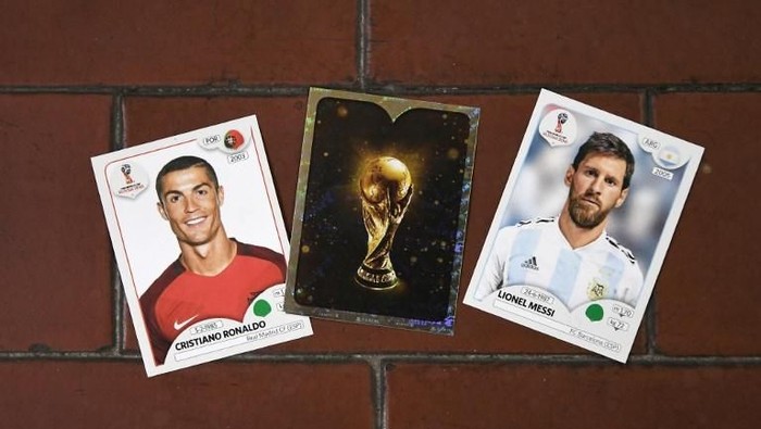 This photo taken on April 20, 2018 shows collectible cards featuring (L-R) Portugals forward Cristiano Ronaldo, the Fifa World Cup Trophy and Argentinas forward Lionel Messi as part of a series featuring players for the 2018 Russia football World Cup at the Panini Group factory in Modena, northern Italy.
The Panini Group holds the rights for the collectible cards of 2018 Russia football World Cup.  / AFP PHOTO / MARCO BERTORELLO