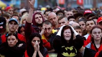 Berpakaian Batman, suporter wanita menangis sedih. REUTERS/Yves Herman.