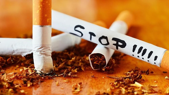 berhenti merokok cigarette, tobacco and stop message isolated on wood background close up shot