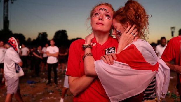 Fan Inggris bersedih seusai kekalahan tim kesayangannya di Piala Dunia 2018, di Hyde Park, London.