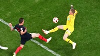 Inggris memang tersingkir oleh Kroasia di semifinal, tapi kipernya layak masuk 11 pemain terbaik di babak ini. Jordan Pickford melakukan lima penyelamatan termasuk saat menghalau tendangan jarak dekat Mario Mandzukic ini. Tapi buruknya pertahanan Inggris secara keseluruhan membuat gawangnya kebobolan dua kali. (Foto: Kai Pfaffenbach/REUTERS)