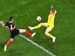 Inggris memang tersingkir oleh Kroasia di semifinal, tapi kipernya layak masuk 11 pemain terbaik di babak ini. Jordan Pickford melakukan lima penyelamatan termasuk saat menghalau tendangan jarak dekat Mario Mandzukic ini. Tapi buruknya pertahanan Inggris secara keseluruhan membuat gawangnya kebobolan dua kali. (Foto: Kai Pfaffenbach/REUTERS)