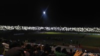 Suporter ramai-ramai menyalakan lampu HP saat stadion mati lampu.
