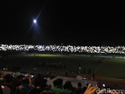 Suporter ramai-ramai menyalakan lampu HP saat stadion mati lampu.