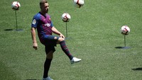 Arthur menimang-nimang bola dengan santai di lapangan yang akan menjadi rumah barunya. (Foto: Albert Gea/Reuters)