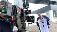 Dalam aktivitas reportasenya mengenai kepindahan Ronaldo, seorang reporter TV di Turin terlihat memamerkan jersey Juventus pemain asal Portugal tersebut. (Foto: Massimo Pinca/Reuters)