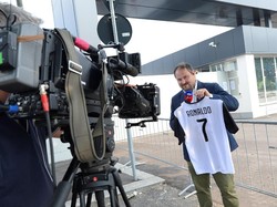 Dalam aktivitas reportasenya mengenai kepindahan Ronaldo, seorang reporter TV di Turin terlihat memamerkan jersey Juventus pemain asal Portugal tersebut. (Foto: Massimo Pinca/Reuters)