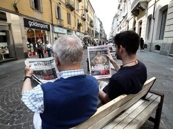 Dua warga beda generasi di kota Turin tampak sedang asyik menyimak kabar megatransfer Ronaldo dari Real Madrid ke Juventus. (Foto: Isabella Bonotto/AFP)