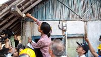 Aksi Rini Pasang Lampu Rumah Warga di Serang