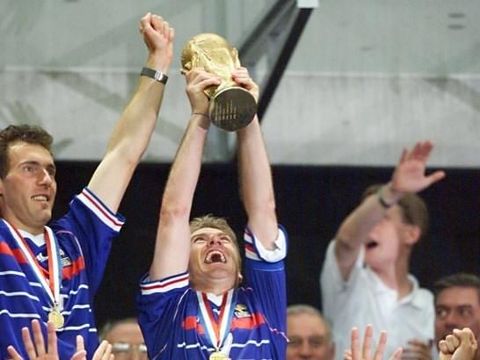(FILES) In this file photo taken on July 12, 1998 French captain Didier Deschamps (C) celebrates as he holds aloft the FIFA Trophy in front of coach Aime Jaccquet at the Stade de France in Saint-Denis, after France won its first-ever world title beating the defending champions Brazil 3-0 in the 1998 World Cup final. The French National Football team prepares to join the final of the Russia 2018 World Cup after beating Belgium 1-0 on July 10, 2018, almost twenty years after France won the World Cup in 1998. / AFP PHOTO / DANIEL GARCIA