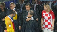 Hujan deras yang mengguyur Luzhniki Stadium tak menghalangi Presiden Kroasia untuk memberi ucapan selamat pada Prancis. Bahkan saat dirinya tidak dipayungi (REUTERS/Maxim Shemetov)