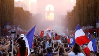 Membawa serta bendera Perancis warga dan suporter penuhi jalan-jalan di Kota Paris untuk merayakan kemenangan Perancis menjadi juara dunia kedua kalinya setelah tahun 1998. Charles Platiau/Reuters.