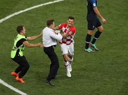 Salah seorang pemain Kroasia tampak bersitegang dengan salah seorang penyusup yang masuk ke lapangan pertandingan dan membuat pertandingan dihentikan sementara waktu. Istimewa/Catherin Ivill/Getty Images.