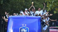 Tim Prancis meninggalkan bandara dengan menumpang bus atap terbuka berwarna biru. Mereka memamerkan trofi Piala Dunia yang direbut di Rusia. Foto: Eric Feferberg/Pool via Reuters