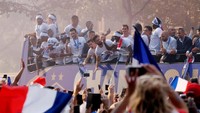 Para pemain Prancis yang berada di atas bus menyapa para warga yang mengelu-elukan mereka. Foto: Jean-Paul Pelissier/Reuters