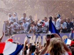 Para pemain Prancis yang berada di atas bus menyapa para warga yang mengelu-elukan mereka. Foto: Jean-Paul Pelissier/Reuters