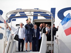 Setelah pintu pesawat terbuka, kapten tim Hugo Lloris yang membawa trofi Piala Dunia muncul bersama pelatih Didier Deschamps. Foto: Pascal Rossignol/Reuters