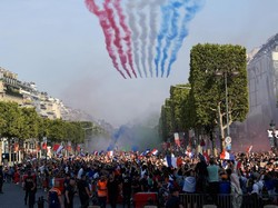 Di tengah parade tersebut, sembilan pesawat tempur Prancis terbang rendah sambil mengeluarkan asap dalam tiga warna bendera nasional: biru, putih, merah. Foto: Eric Feferberg/Pool via Reuters