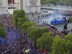 Bus yang membawa tim Prancis tiba di Champs Elysees dan mendapatkan sambutan meriah dari warga yang sudah menantikan mereka. Foto: Gonzalo Fuentes/Reuters