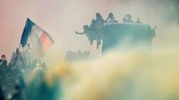 Banyak di antara warga Paris yang menyalakan flare untuk merayakan kepulangan tim nasional mereka. Foto: Charles Platiau/Reuters