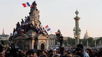 Saking sesaknya jalanan di Paris, sebagian warga sampai memanjat bangunan untuk menyaksikan parade ini. Foto: Jean-Paul Pelissier/Reuters