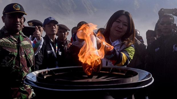 Lagenda bulu tangkis Indonesia Susi Susanti (tengah) menyalakan kaldron dengan obor Asian Games 2018 saat prosesi Torch Relay Asian Games 2018 di Gunung Bromo, Probolinggo, Sabtu (21/7).