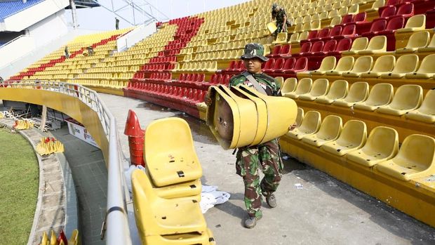 Anggota TNI dari satuan Yon Zikon 12 / Karana Jaya membantu proses perbaikan Stadion Jakabaring pada Senin (23/7).